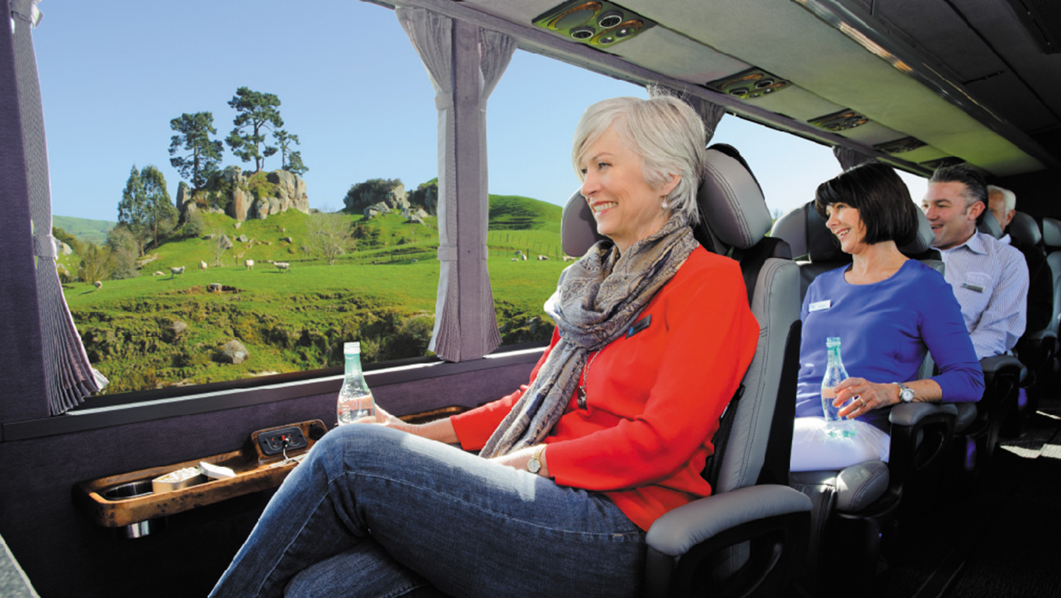 Reisende genießen den Panoramablick aus einem komfortablen Reisebus in Neuseeland